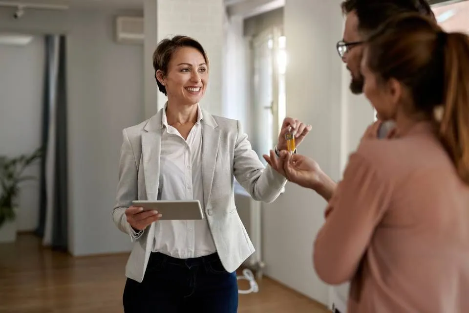 Real estate professional handing keys to a couple